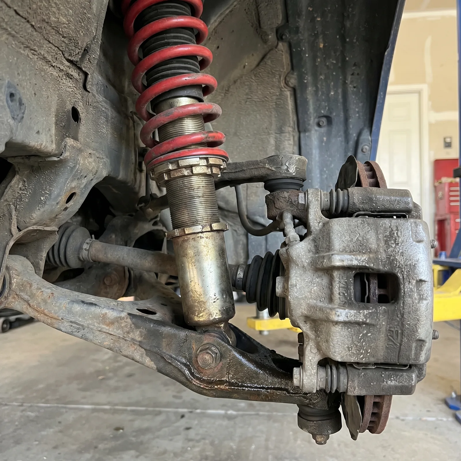 Front suspension on the rack at Jack's &mdash; coilover, control arm, tie rod end and ball joint, the parts an alignment depends on